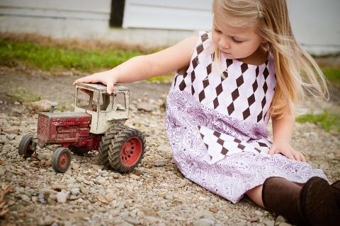 A toy tractor and a girl. The Thai for "a toy tractor and a girl" is "รถแทรกเตอร์ของเล่นและเด็กผู้หญิง". A toy tractor and a girl. The Thai for "a toy tractor and a girl" is "รถแทรกเตอร์ของเล่นและเด็กผู้หญิง".