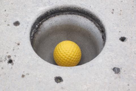 A yellow golf ball in the hole. The Thai for "a yellow golf ball in the hole" is "ลูกกอล์ฟสีเหลืองในหลุม". A yellow golf ball in the hole. The Thai for "a yellow golf ball in the hole" is "ลูกกอล์ฟสีเหลืองในหลุม".