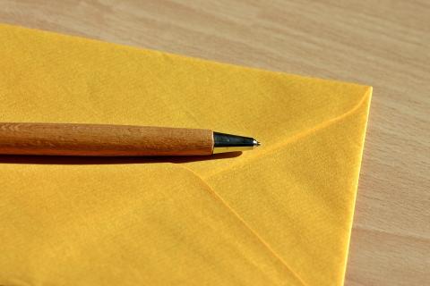 A pen on a yellow envelope. The Thai for "a pen on a yellow envelope" is "ปากกาบนซองจดหมายสีเหลือง". A pen on a yellow envelope. The Thai for "a pen on a yellow envelope" is "ปากกาบนซองจดหมายสีเหลือง".