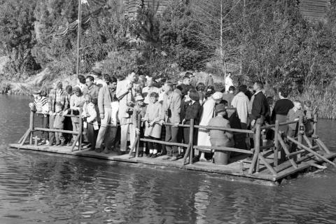 Many people on a raft. The Thai for "many people on a raft" is "คนจำนวนมากบนแพ".