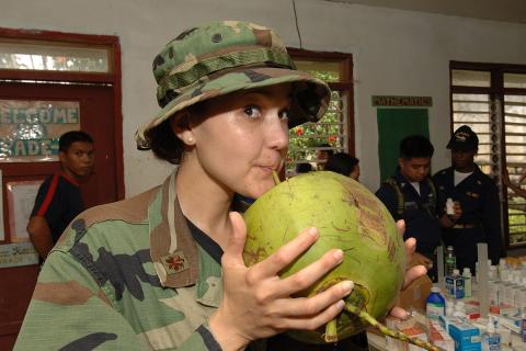 A female soldier is drinking coconut juice.. The Thai for "A female soldier is drinking coconut juice." is "ทหารหญิงกำลังดื่มน้ำมะพร้าว". A female soldier is drinking coconut juice.. The Thai for "A female soldier is drinking coconut juice." is "ทหารหญิงกำลังดื่มน้ำมะพร้าว".