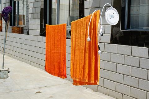 Two orange towels on a clothesline. The Thai for "two orange towels on a clothesline" is "ผ้าเช็ดตัวสีส้มสองผืนบนราวตากผ้า". Two orange towels on a clothesline. The Thai for "two orange towels on a clothesline" is "ผ้าเช็ดตัวสีส้มสองผืนบนราวตากผ้า".