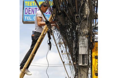 An electrician on a bamboo ladder. The Thai for "an electrician on a bamboo ladder" is "ช่างไฟฟ้าบนบันไดไม้ไผ่". An electrician on a bamboo ladder. The Thai for "an electrician on a bamboo ladder" is "ช่างไฟฟ้าบนบันไดไม้ไผ่".
