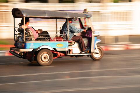 A tuk-tuk driving on the road. The Thai for "a tuk-tuk driving on the road" is "ตุ๊ก ตุ๊กวิ่งบนถนน". A tuk-tuk driving on the road. The Thai for "a tuk-tuk driving on the road" is "ตุ๊ก ตุ๊กวิ่งบนถนน".