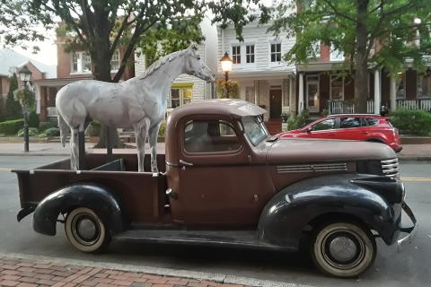 A statue of a horse on a pickup truck. The Thai for "a statue of a horse on a pickup truck" is "รูปปั้นม้าบนรถปิ๊คอัพ". A statue of a horse on a pickup truck. The Thai for "a statue of a horse on a pickup truck" is "รูปปั้นม้าบนรถปิ๊คอัพ".
