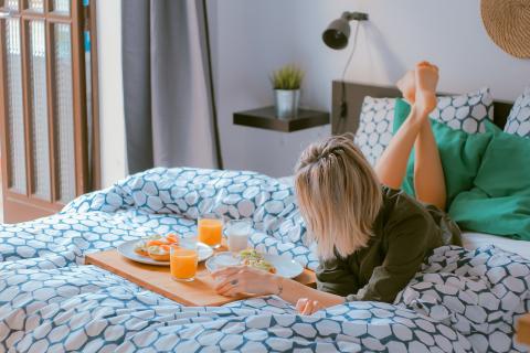 A woman eating breakfast on a bed. The Thai for "a woman eating breakfast on a bed" is "ผู้หญิงกินอาหารเช้าบนที่นอน". A woman eating breakfast on a bed. The Thai for "a woman eating breakfast on a bed" is "ผู้หญิงกินอาหารเช้าบนที่นอน".