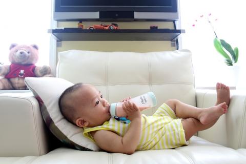 A baby with his bottle in an armchair. The Thai for "a baby with his bottle in an armchair" is "เด็กทารกกับขวดนมของเขาบนเก้าอี้นวม". A baby with his bottle in an armchair. The Thai for "a baby with his bottle in an armchair" is "เด็กทารกกับขวดนมของเขาบนเก้าอี้นวม".
