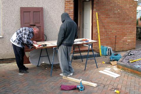 Two carpenters repairing a door. The Thai for "two carpenters repairing a door" is "ช่างไม้สองคนกำลังซ่อมประตู". Two carpenters repairing a door. The Thai for "two carpenters repairing a door" is "ช่างไม้สองคนกำลังซ่อมประตู".