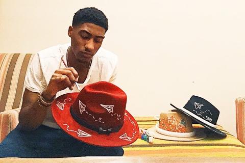 A man painting on a hat. The Thai for "a man painting on a hat" is "ผู้ชายวาดรูปบนหมวก". A man painting on a hat. The Thai for "a man painting on a hat" is "ผู้ชายวาดรูปบนหมวก".